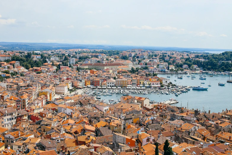 a view from above of some orange roofs and boats