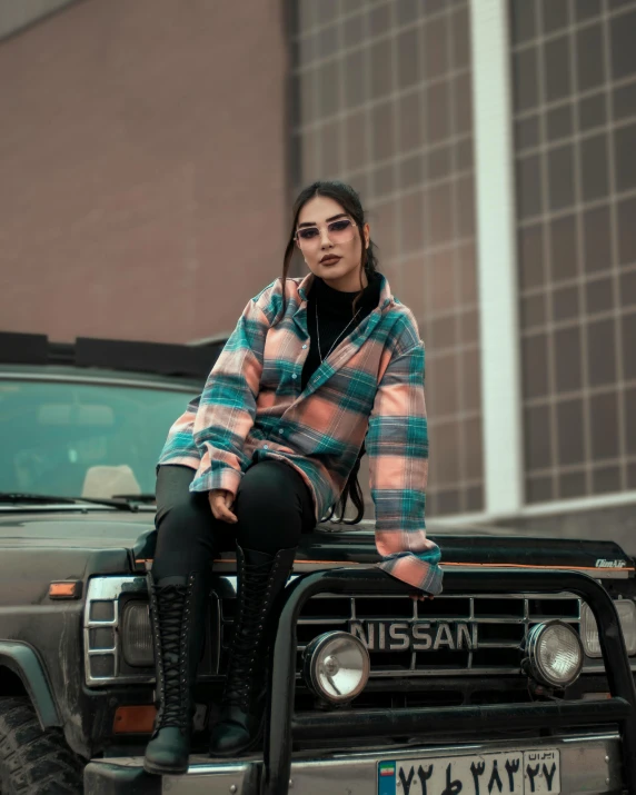 a woman sitting on the hood of her car