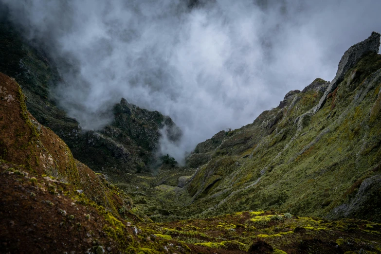 a view of mountains covered in clouds from behind