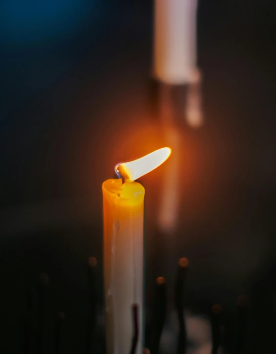 the flame of an lit candle is starting to glow yellow