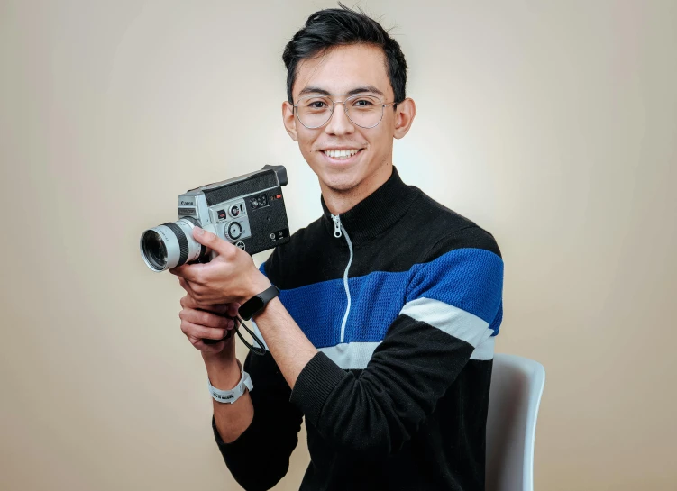 a man holding a camera poses for a po