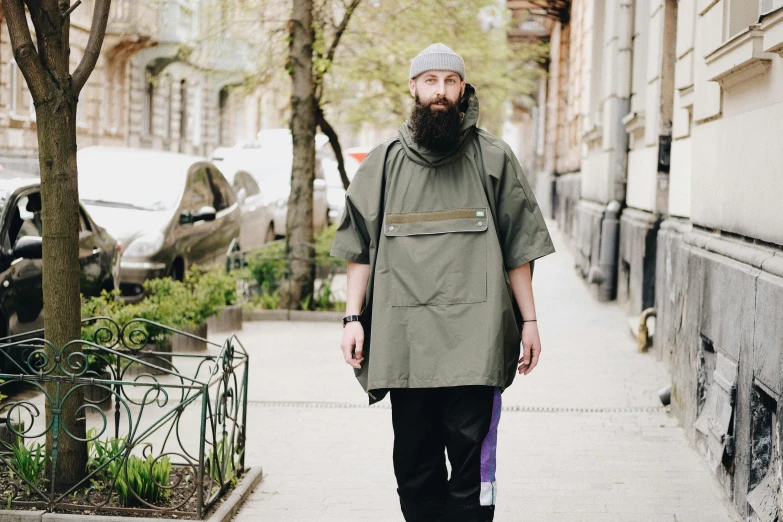 a bearded man walks down the street with his bag