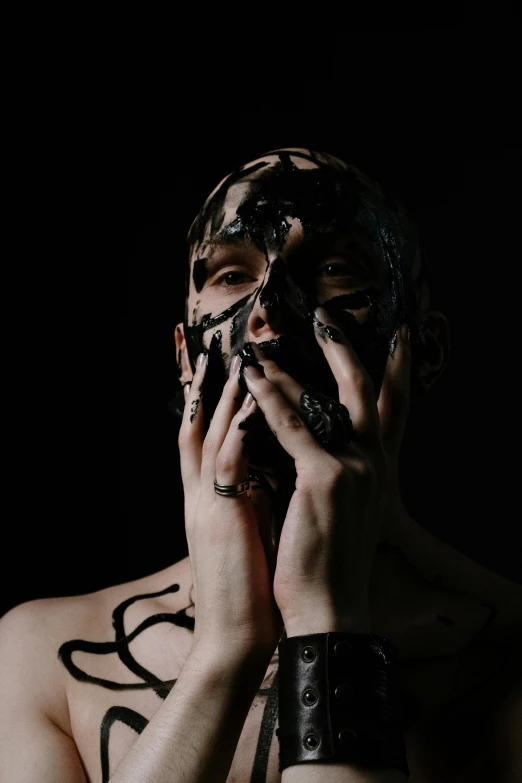 a man covered in black paint talking on a phone