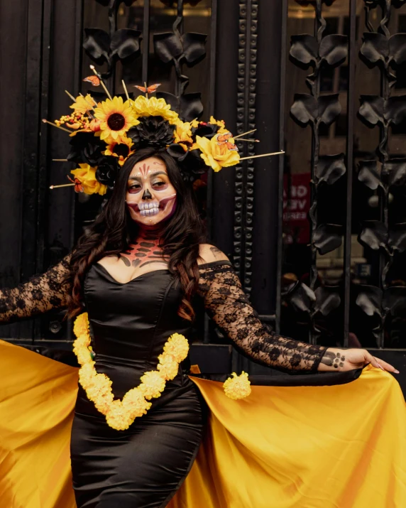 a woman in costume poses in front of an iron gate