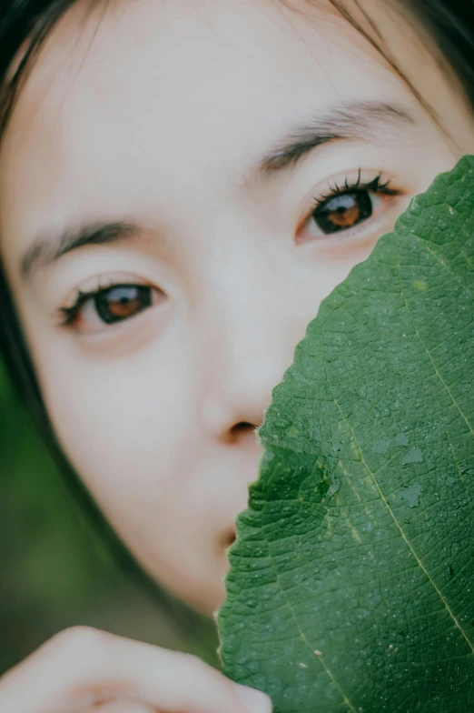 a woman looking at a leaf through the lens