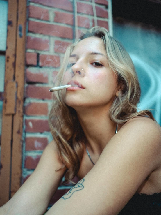 a woman sitting on a bench smoking a cigarette