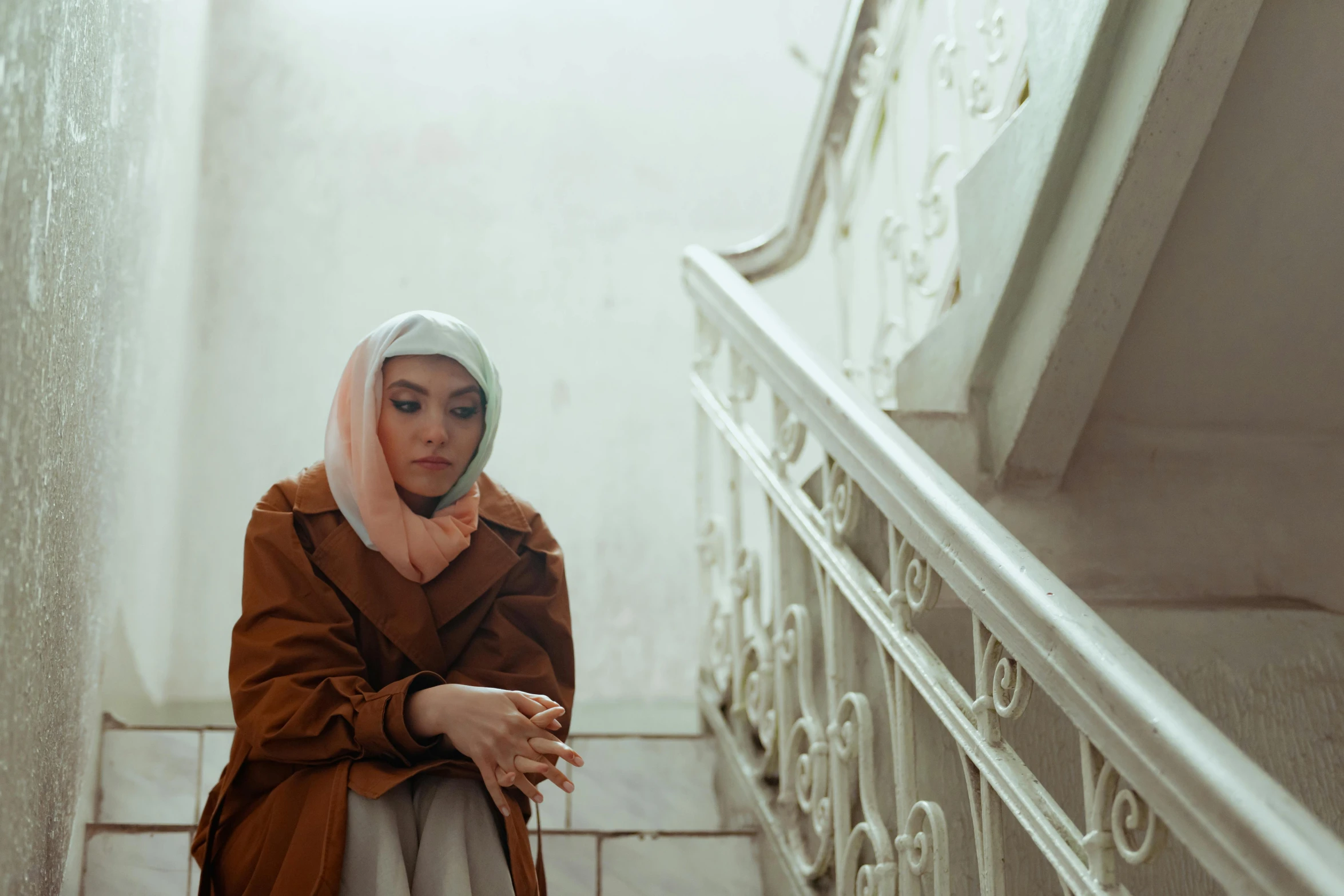 a young woman in brown and white sitting on a set of stairs