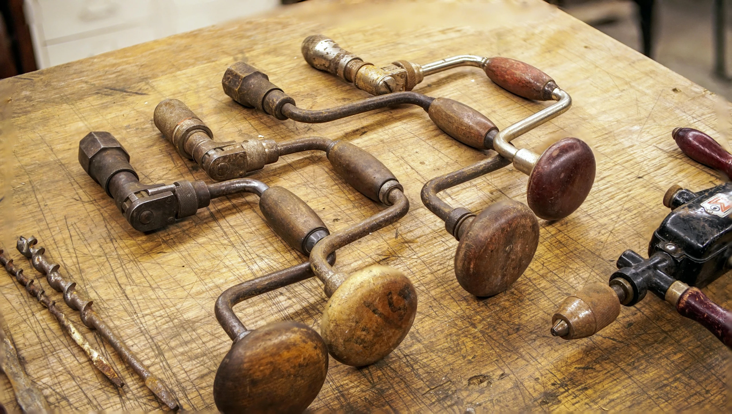 a bunch of metal work tools sitting on top of a wooden surface