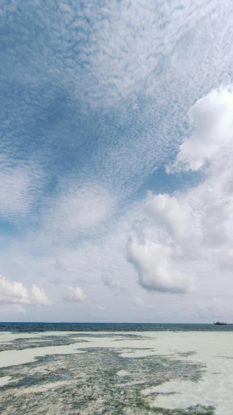 a large body of water sitting under a blue sky