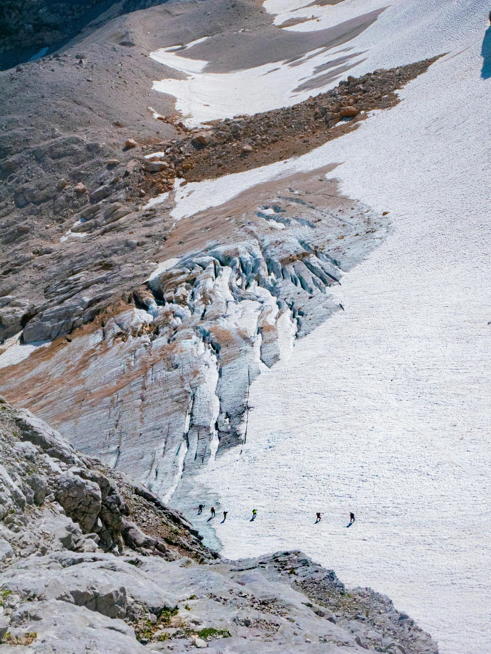 a couple people walking up the side of a mountain