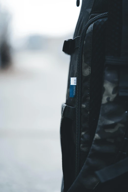 a black bag with small badges and some silver colored beads on it