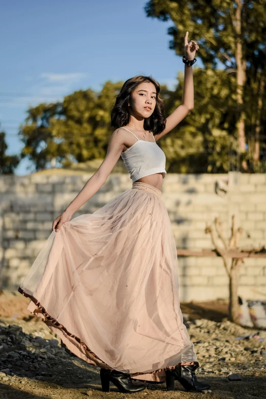 a woman is wearing a light pink long skirt