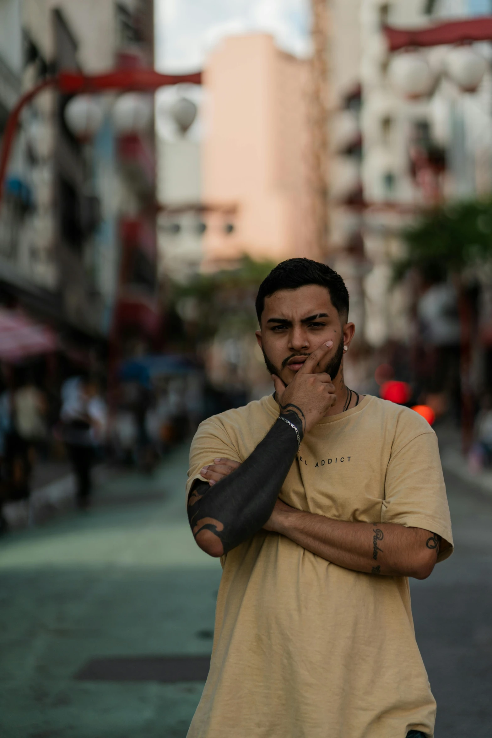 a man standing on the side of a city street with his hands in his mouth