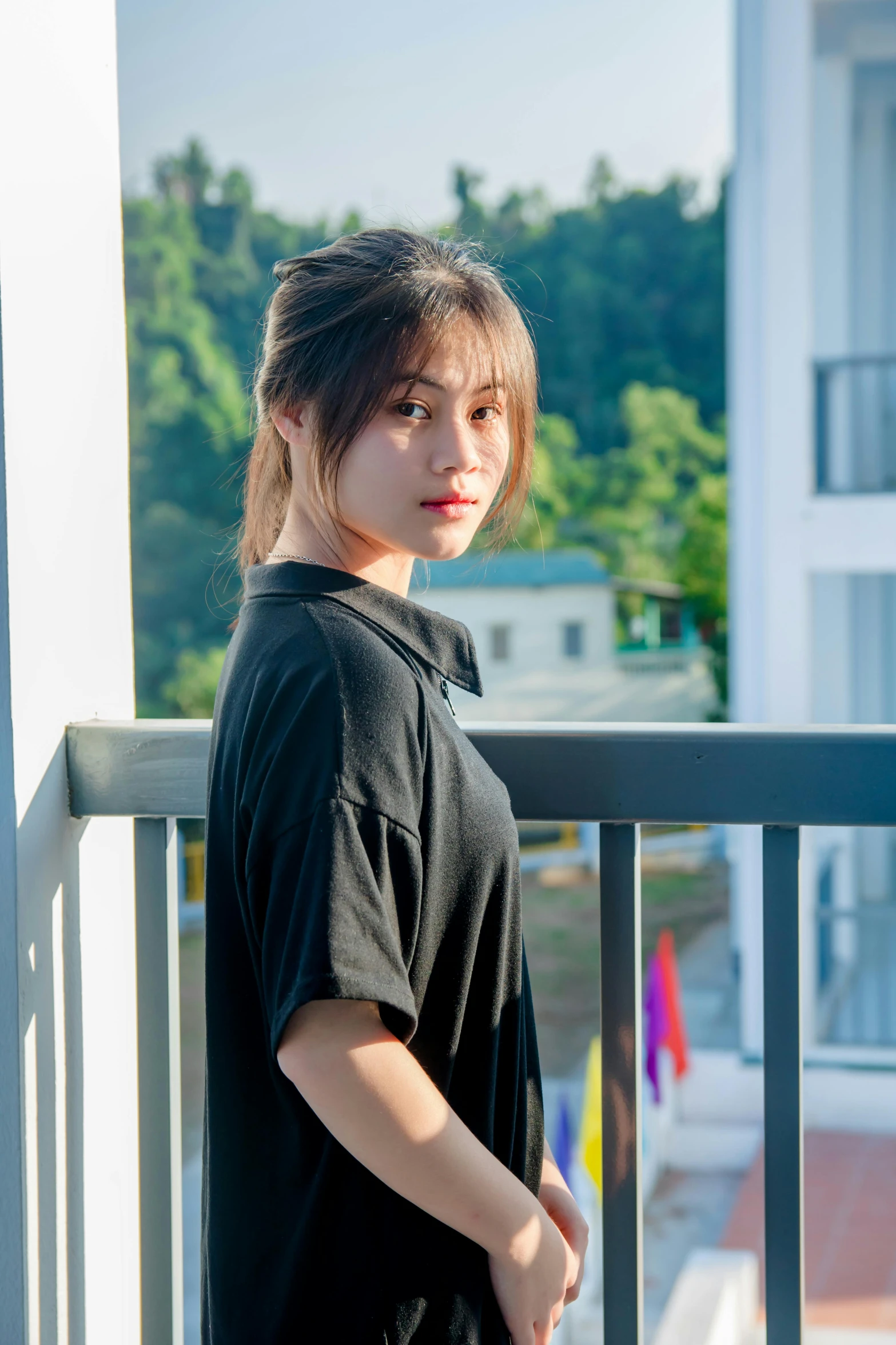 an asian woman standing outside on a balcony looking in camera