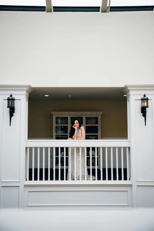 a woman standing on the balcony of a home