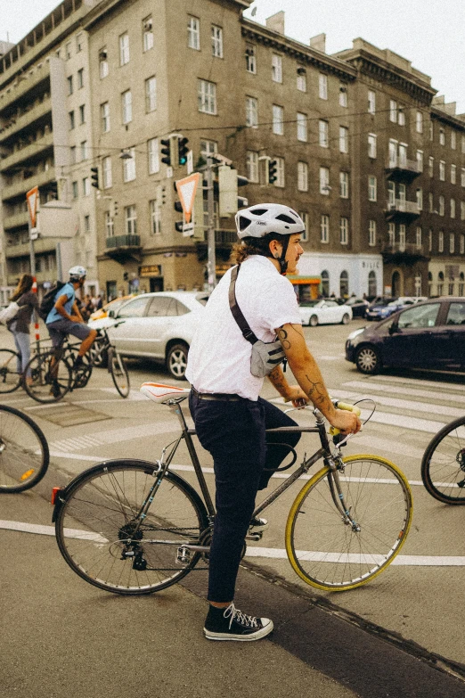 a man standing in the middle of a road with two bikes