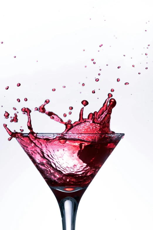 pink beverage splash in a glass filled with liquid