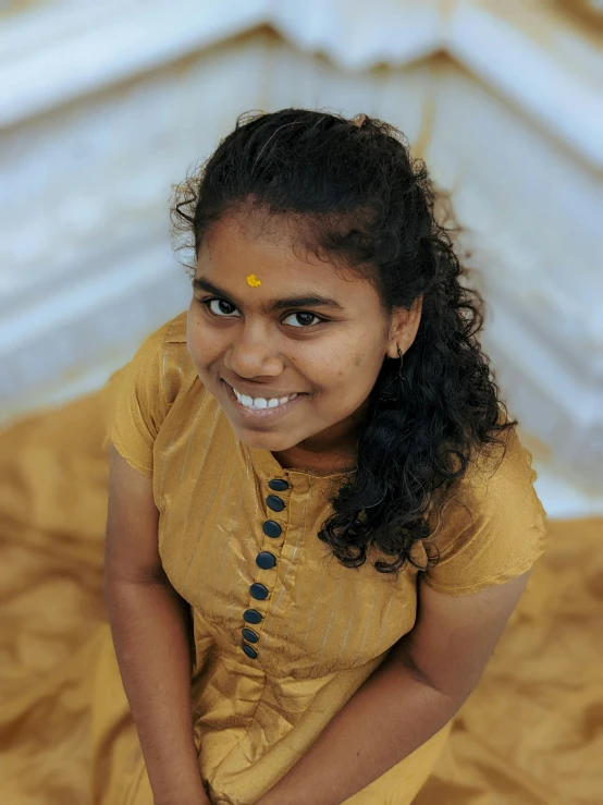 a young indian girl is smiling and looking towards the camera