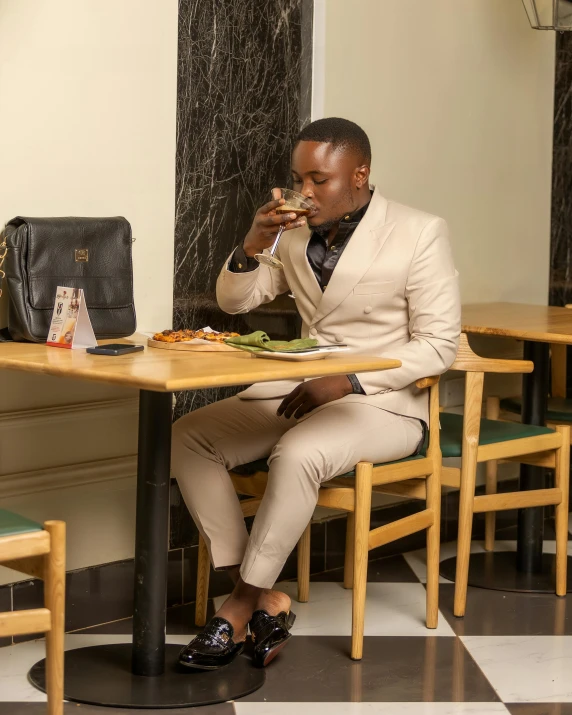 a man in a white suit eating at a table