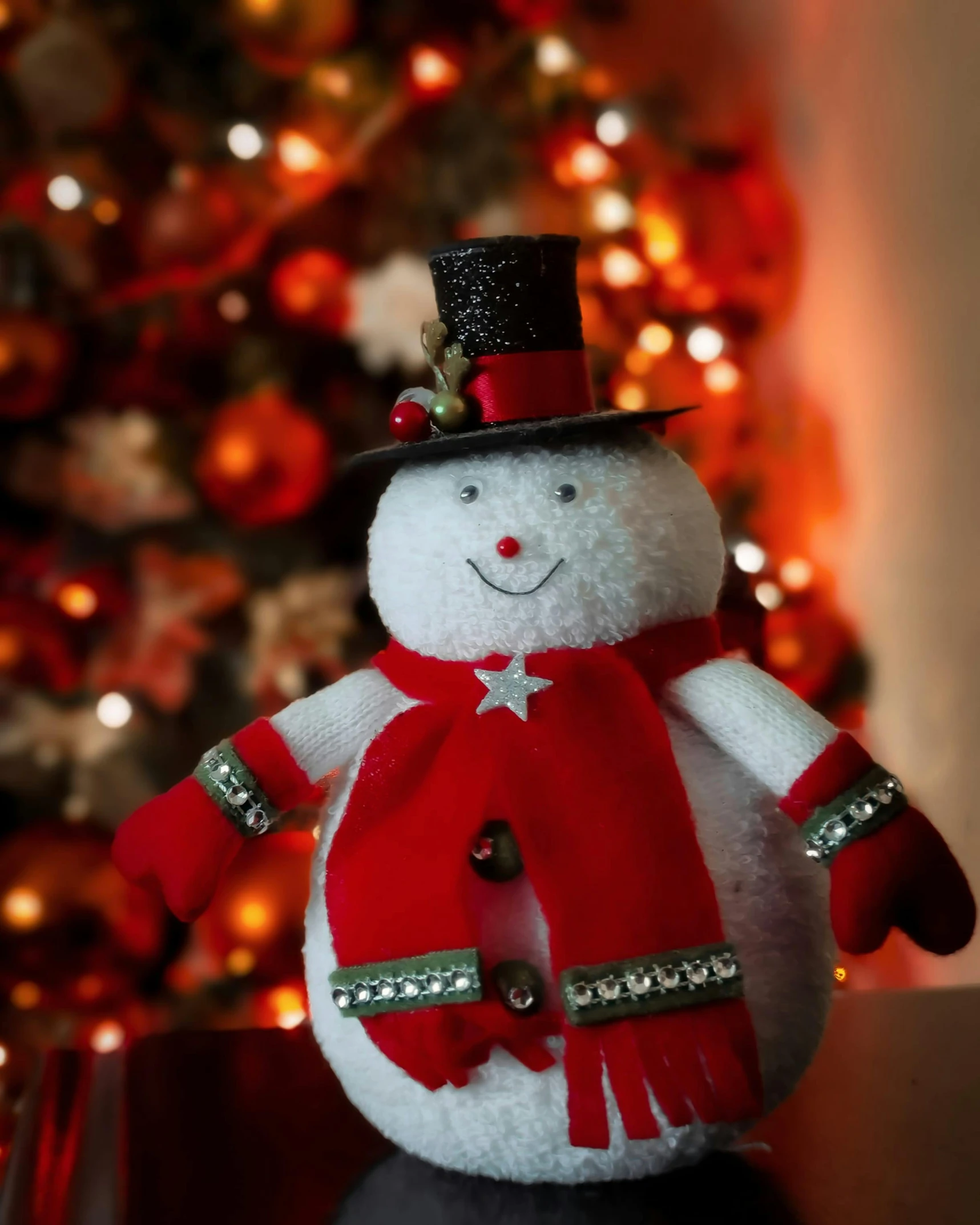 a small snowman with red and white pants and top hat and mittens