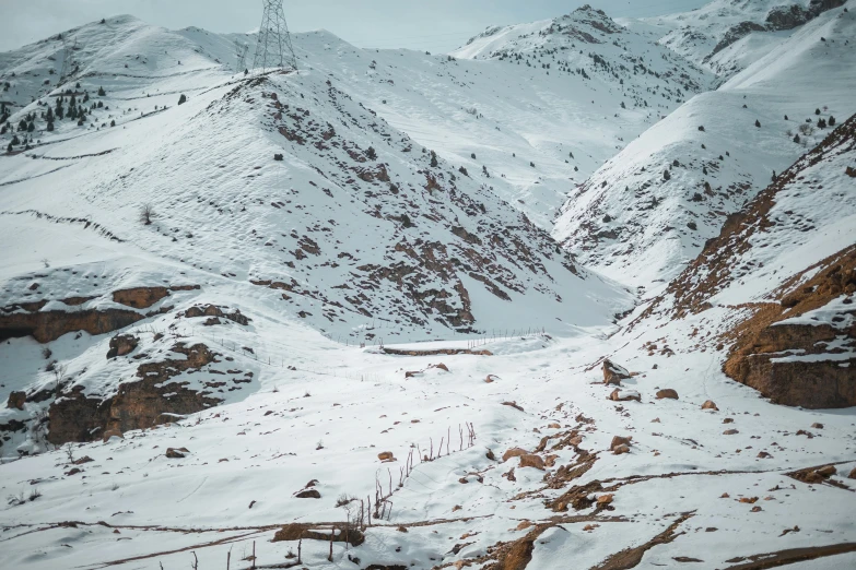 a mountain side covered in snow with the top part of the mountains covered with snow