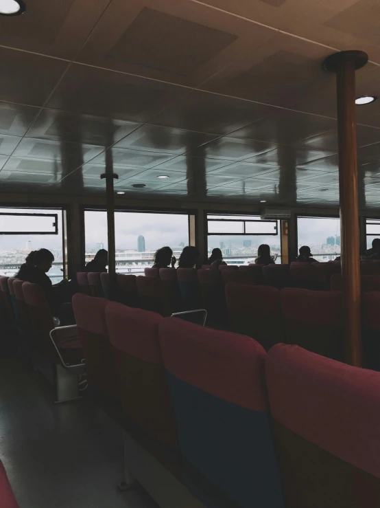 people sitting in seats looking out the window on a train