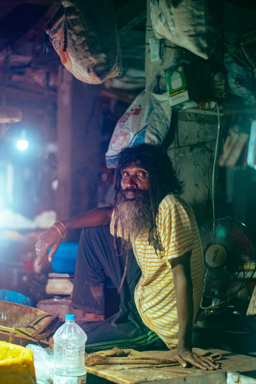 an old man sitting next to a wooden table