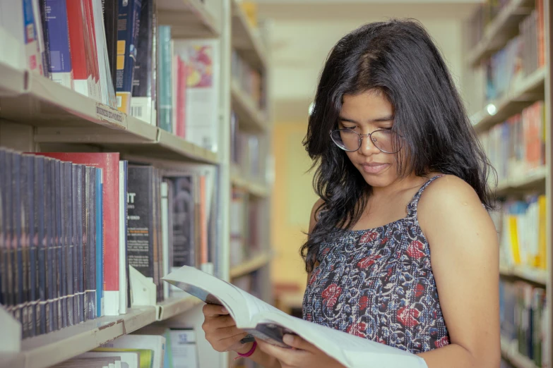 a girl is reading a book in the liry