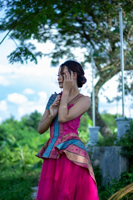 a woman standing in a green field talking on her phone