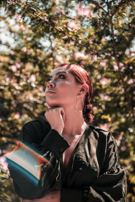 a beautiful woman standing in front of a tree