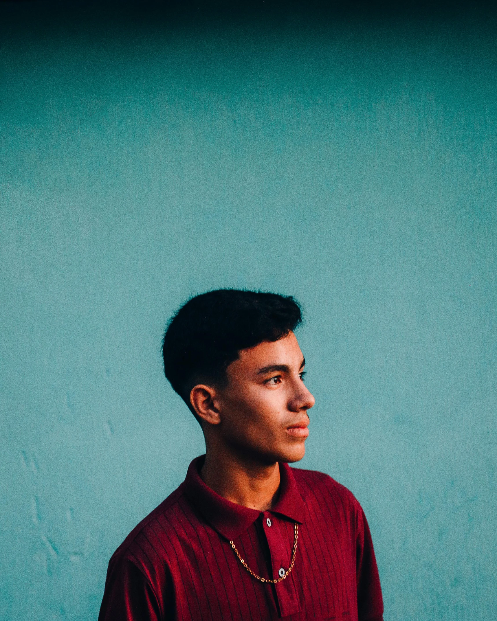 a man standing in front of a wall with a green background