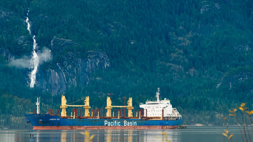 a large ship with lots of large rigs on its sides is anchored in the water