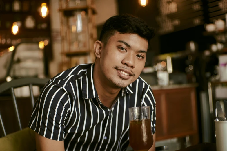 a man sitting at a table with a glass of beer