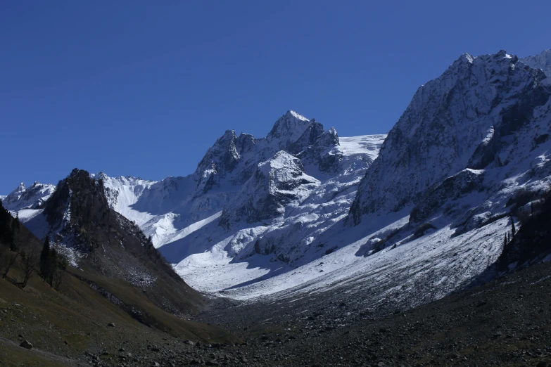 the mountains covered in snow under a blue sky