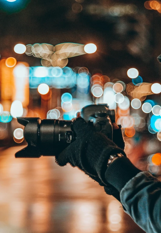 an open camera being held up by someone with blurry lights