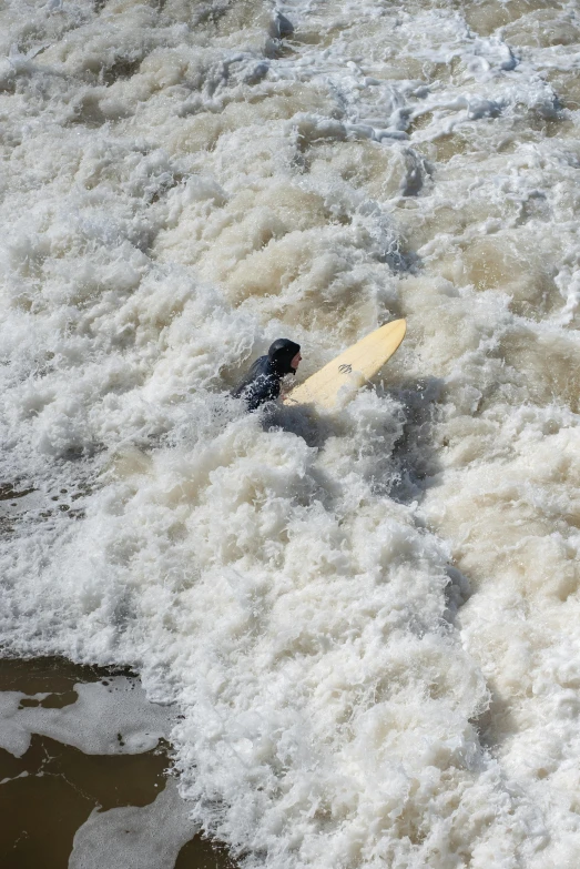 an aerial view of a surfboard in rough surf