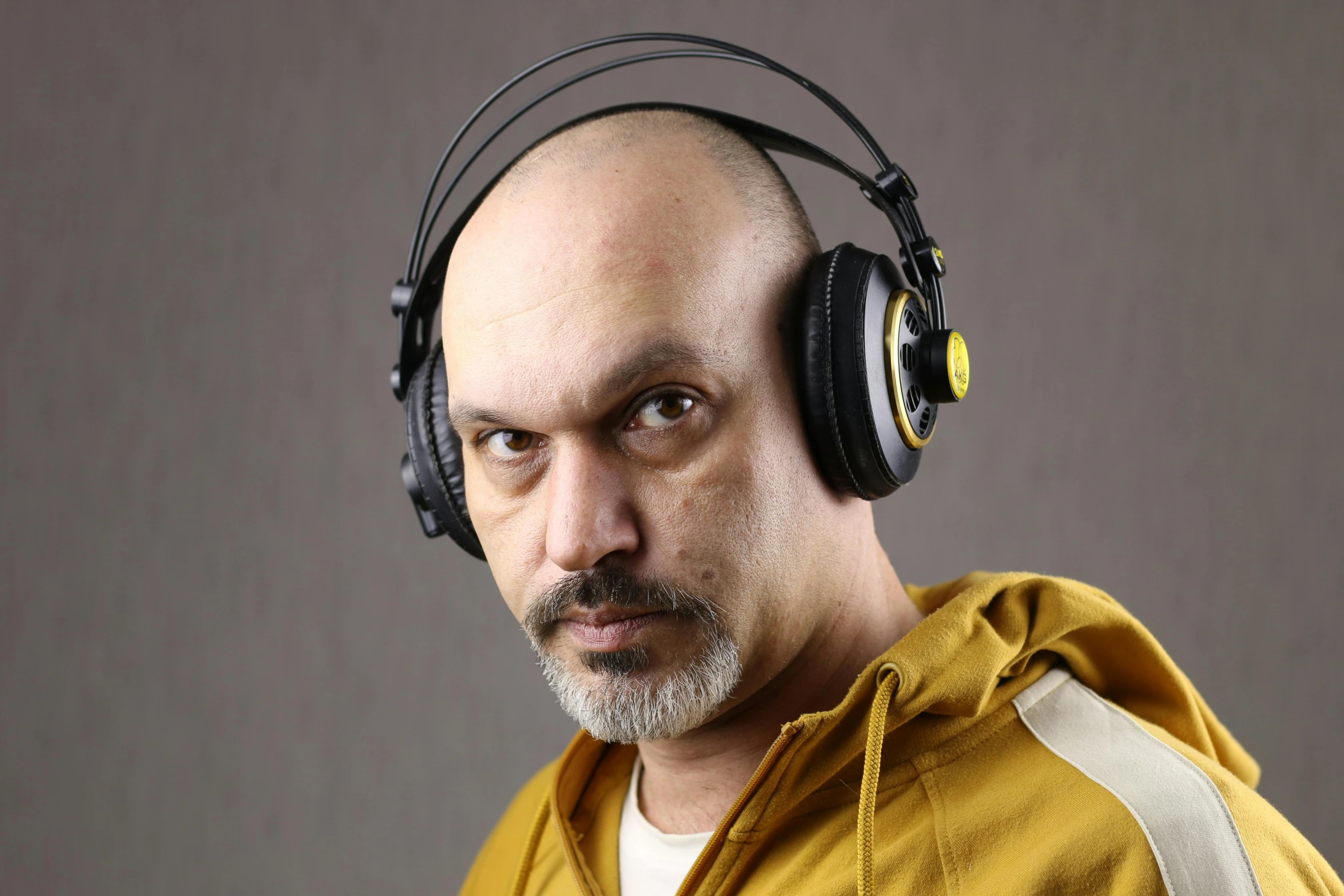 a bald man with headphones on his head