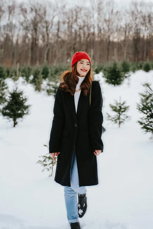 woman standing in front of trees on snowy surface
