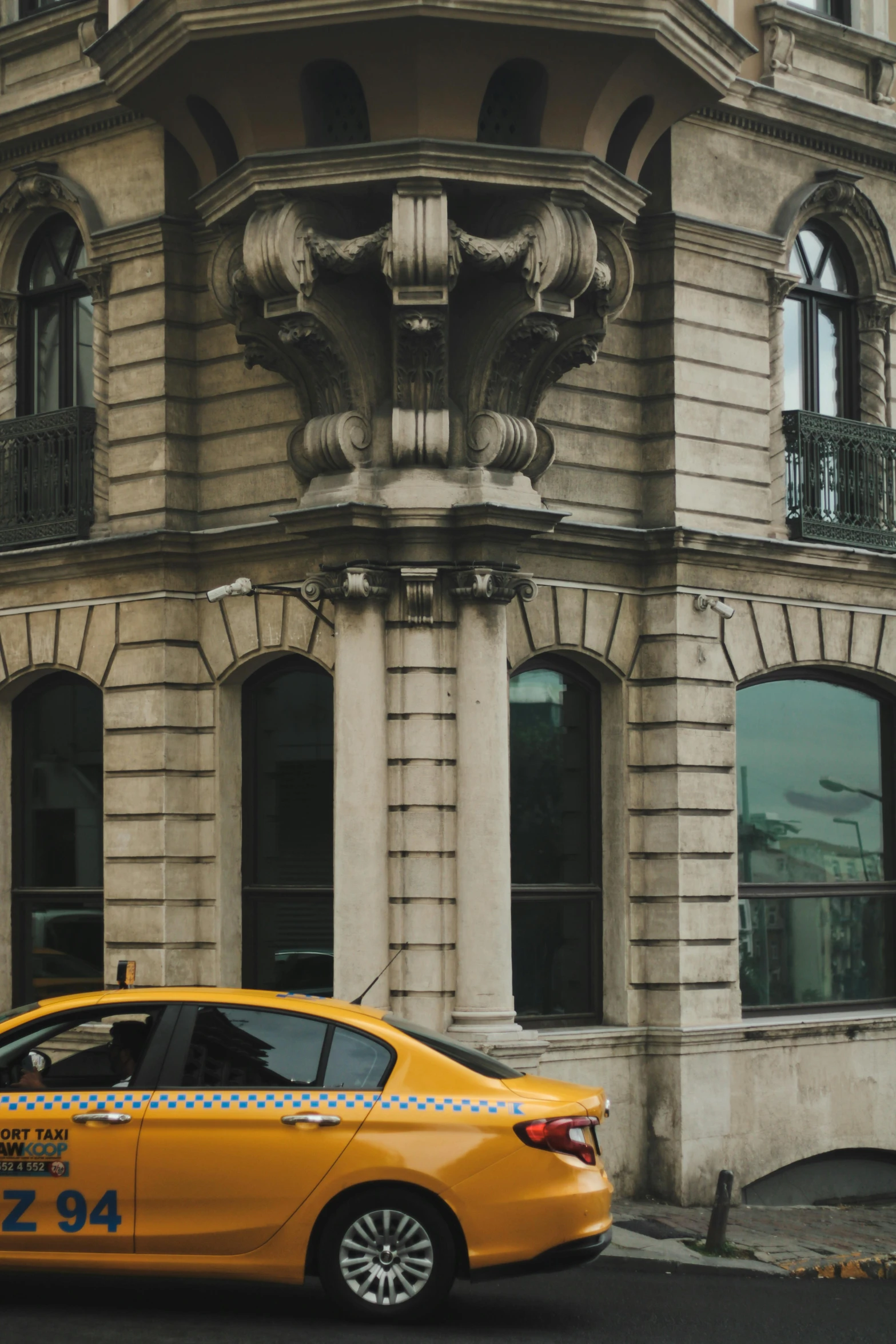 a taxi car parked next to a very large building