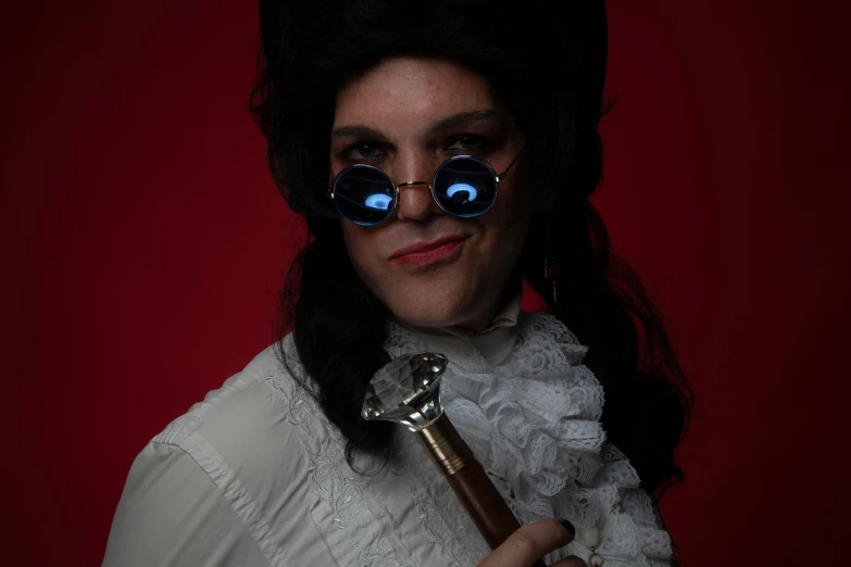 a woman with blue eyes and black hair holding a long silver key