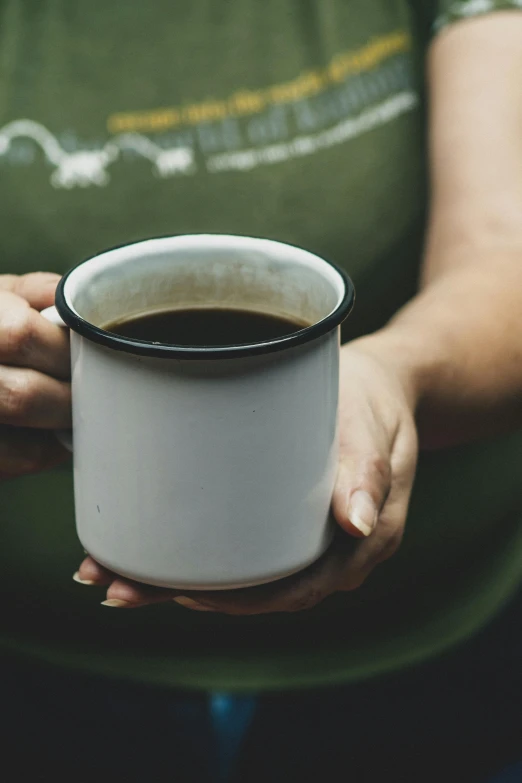 the person is holding out a coffee cup