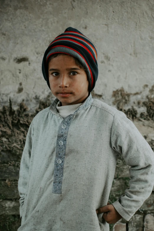 a little boy wearing a hat and a  top