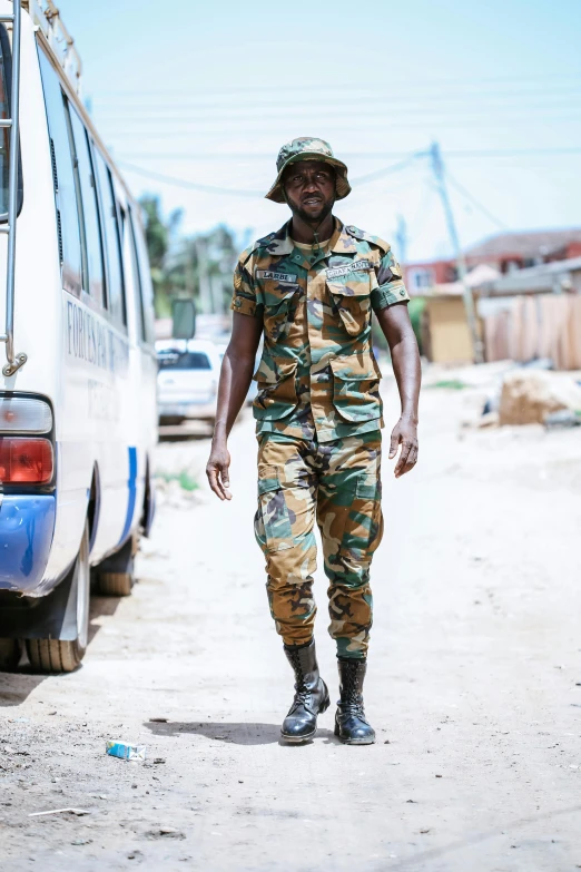 a soldier walking along the street carrying soing