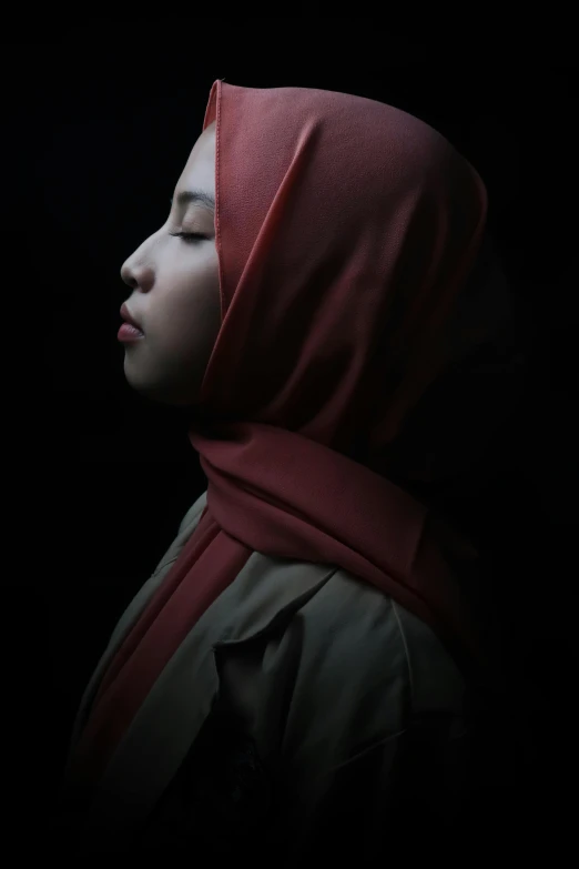 a woman with her head covered in a red scarf