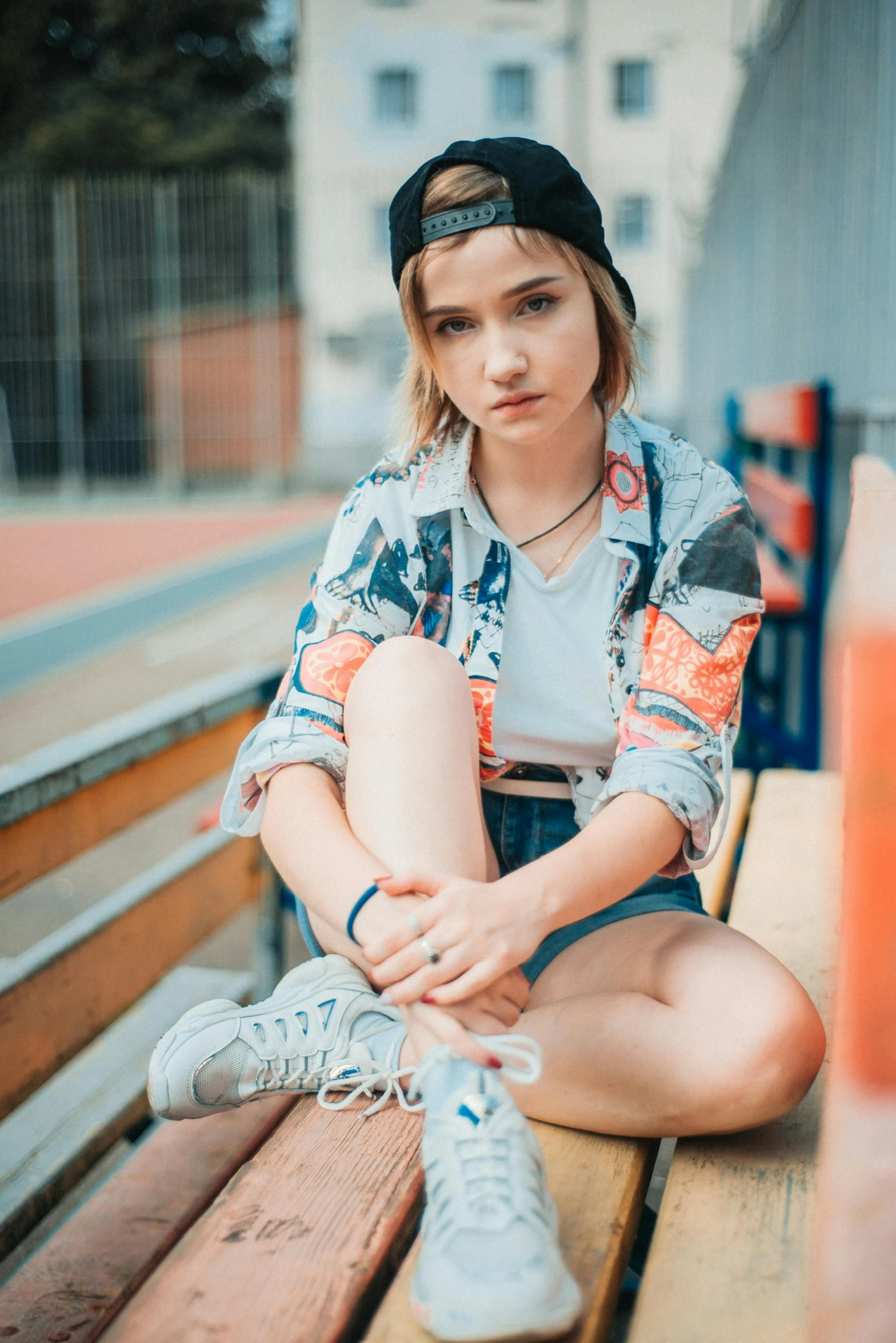 a beautiful young blonde sitting on top of a wooden bench