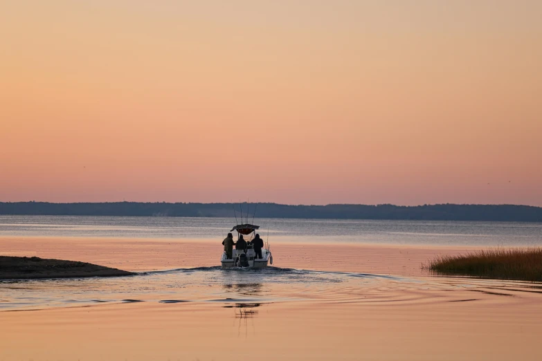 three people riding in a small boat in the ocean