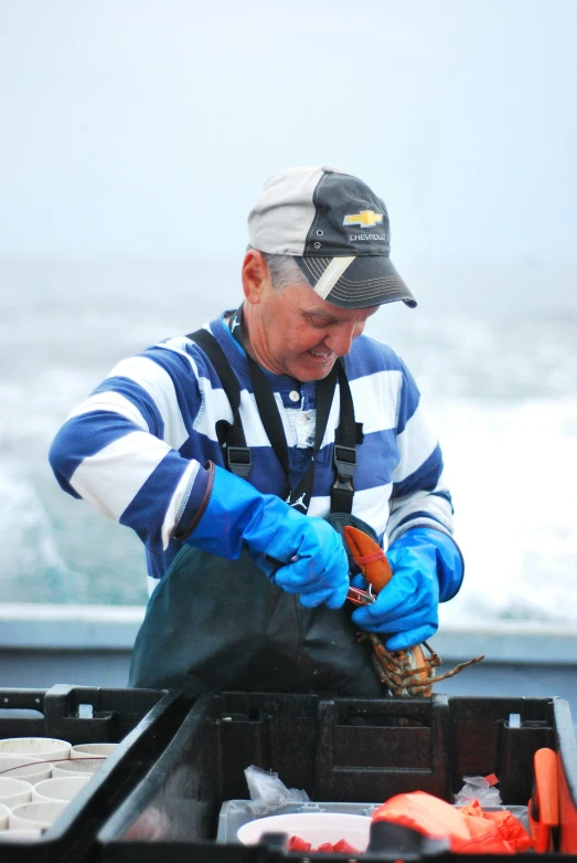 a man holding an object in his hand while standing on the top of a boat