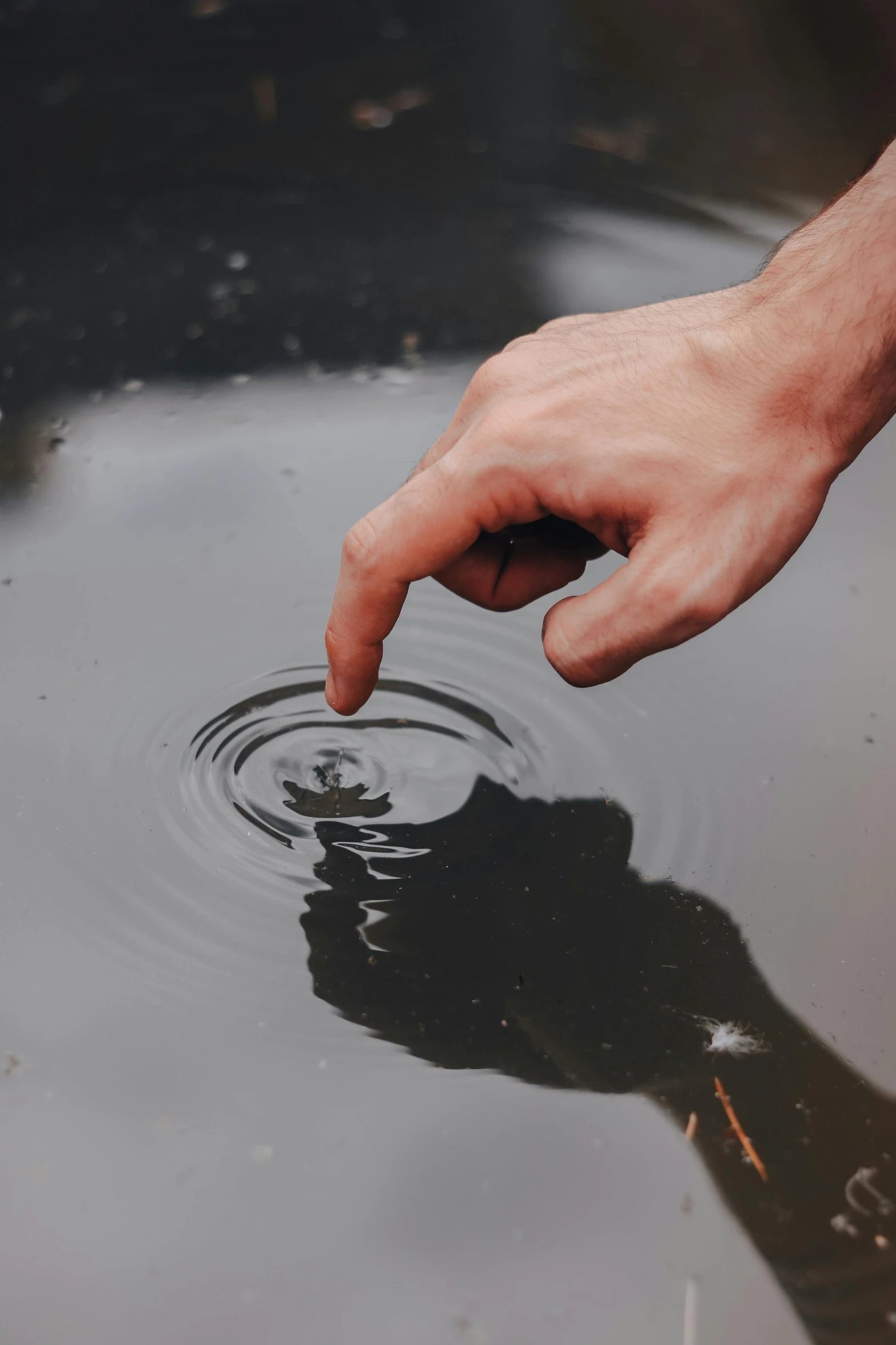 a person reaches into the water towards their hand