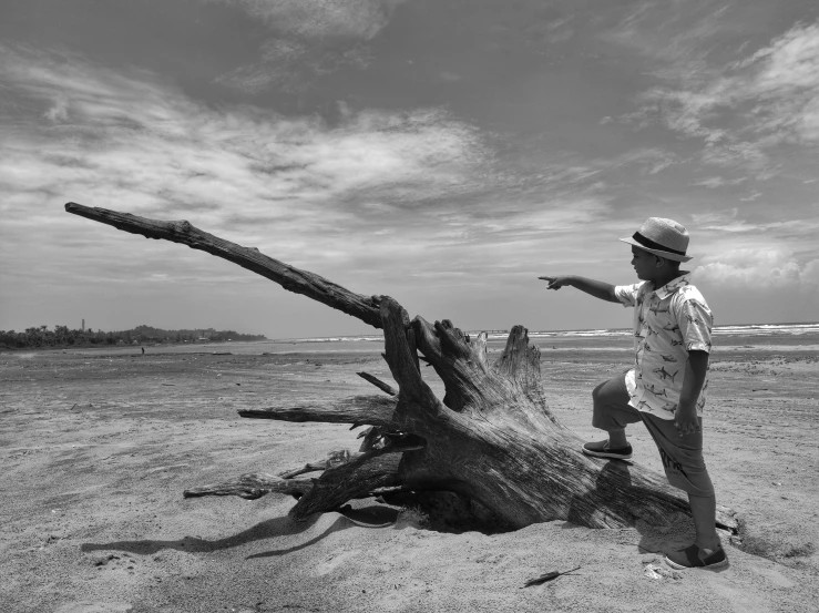 a man standing next to a large log