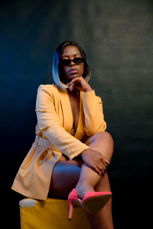 a woman wearing a yellow suit sitting on top of a stool